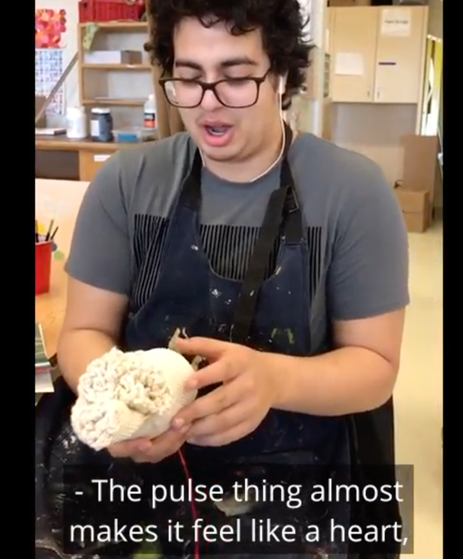 Young man holds ceramic piece in his hand and has reaction to its virations and sound